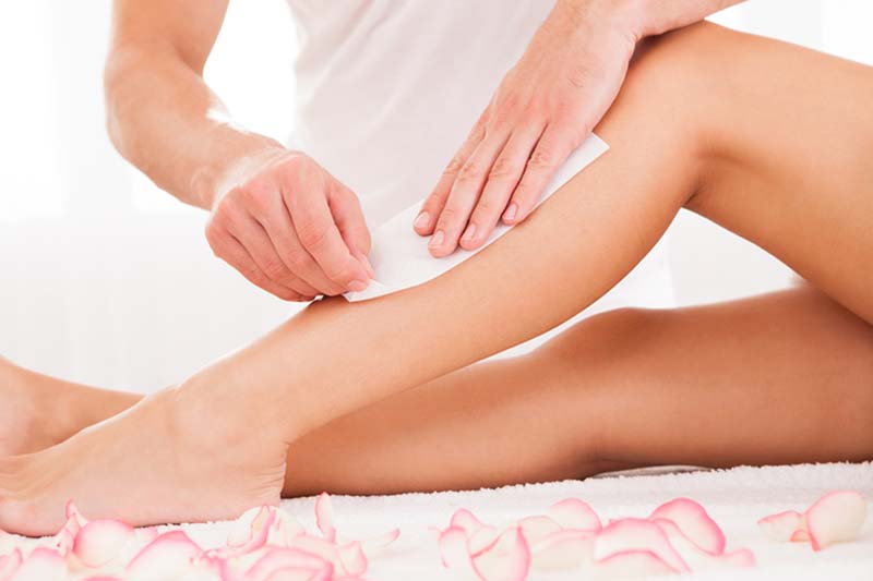 Man waxing a woman's leg